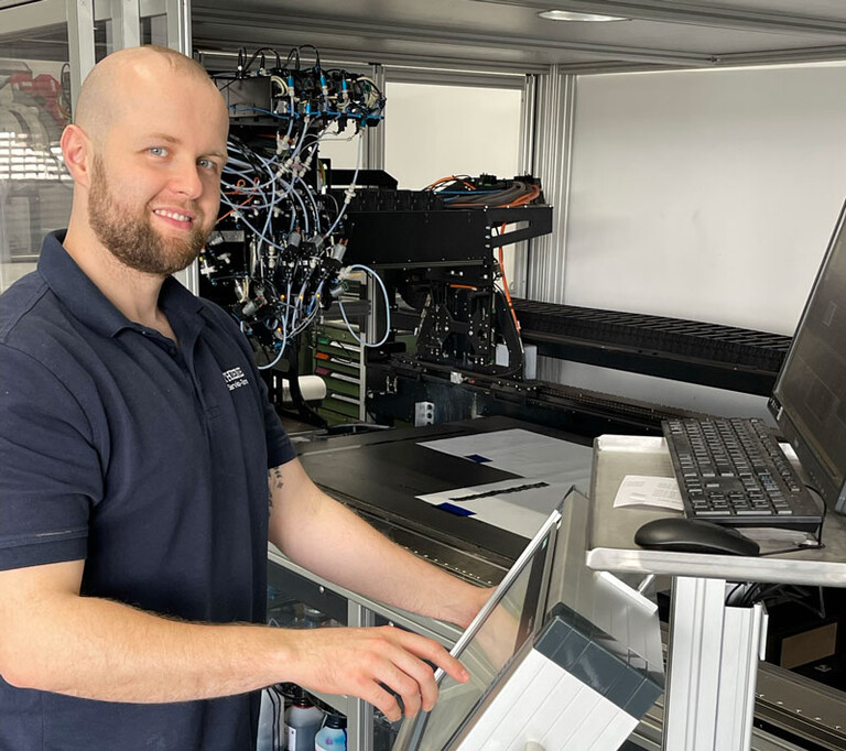 Sein Arbeitsplatz die Digitaldruckmaschine Herr Kraft an einer Digitaldruckmaschine